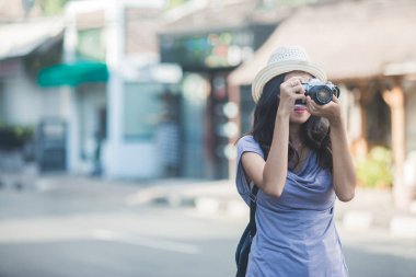 Genç backpacker Vintage kamera ile fotoğraf çekmek