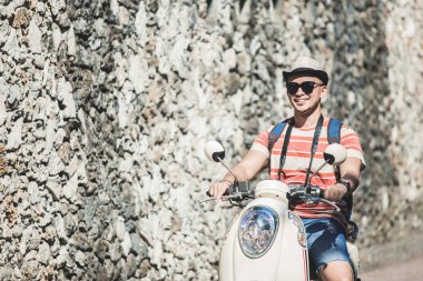 Genç backpacker güneşli tatil sırasında motosiklet sürme