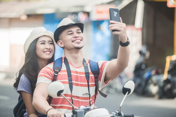 Dos jóvenes mochileros tomando selfies usando móviles cámara w —  Fotos de Stock