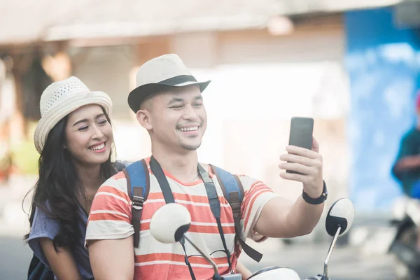 Två unga backpackers som tar selfies med mobiltelefoner kamera w — Stockfoto