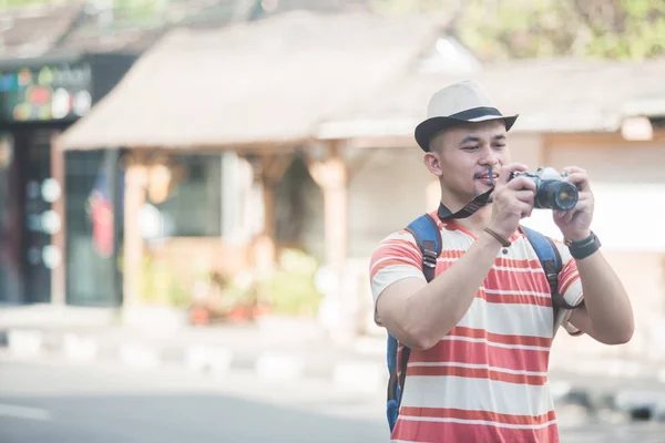 Young backpacker taking photos using vintage camera — Stock Photo, Image