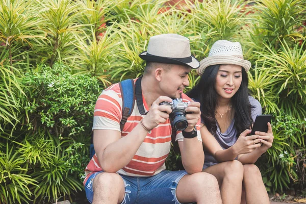 Young travellers taking a rest on the side of the road during su — Stock Photo, Image