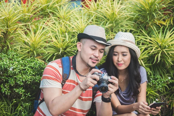 Backpackers couple see the result of their photo on camera — Stock Photo, Image