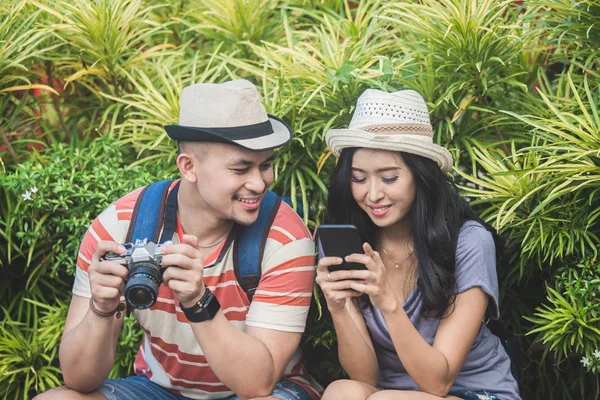 Young travellers taking a rest on the side of the road during su — Stock Photo, Image