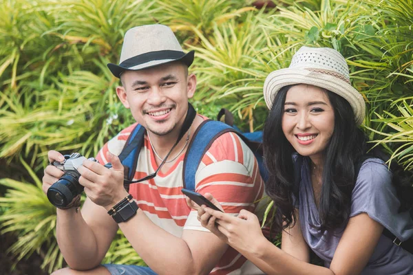 Due zaino in spalla con cappello estivo sorridente alla macchina fotografica — Foto Stock