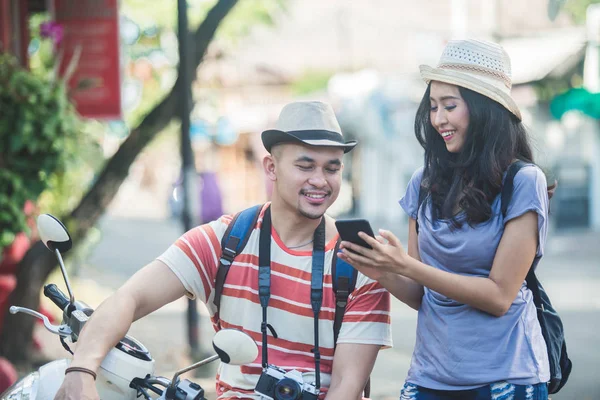 Dos mochileros con sombrero de verano viendo el resultado de su foto —  Fotos de Stock