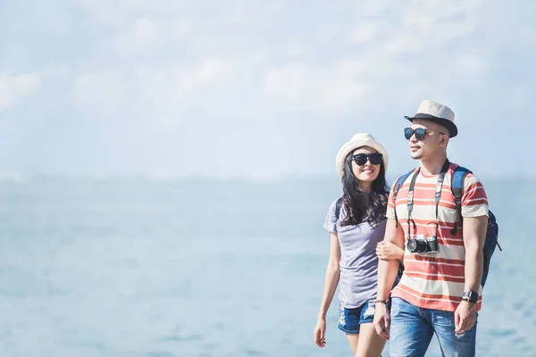 Mochileros pareja con sombrero de verano y gafas de sol caminando en —  Fotos de Stock