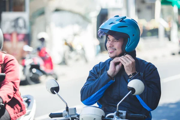 Motorcycle taxi driver fastening his helmet for safety riding — Stock Photo, Image