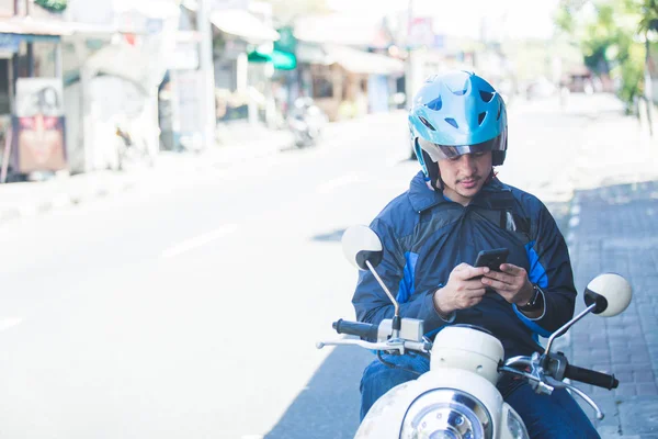 Mototaxista mensagens de texto no celular na lateral do — Fotografia de Stock
