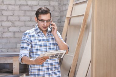 marangoz malzemeleri Katalog marangoz Atölyesi'nde bakarken onun müvekkili ile telefonda konuşurken portresi