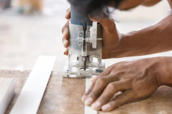 Рабочие руки резки края деревянной доски с помощью ладонной пилы — стоковое фото