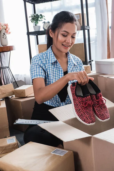 woman packing of shoes on carton boxes