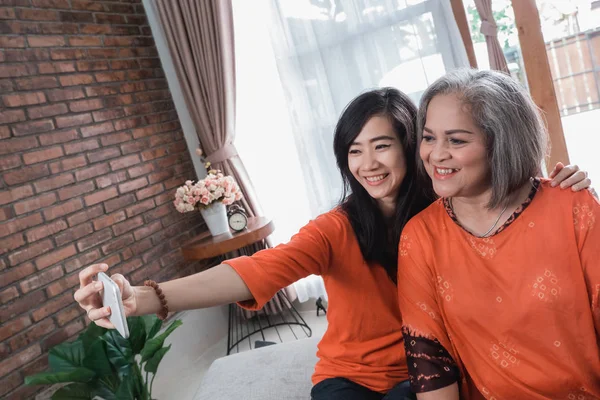 Rijpe moeder en dochter doen selfie — Stockfoto