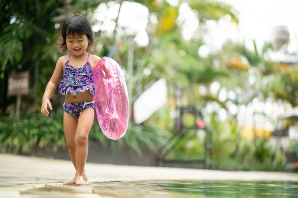 Улыбающаяся девочка, играющая в бассейне — стоковое фото