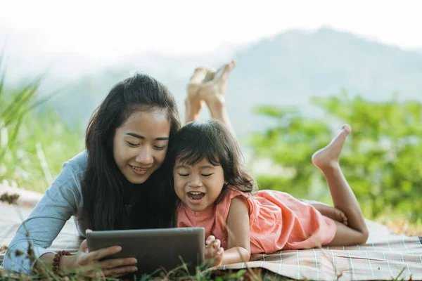 Frauen und seine Tochter schauen gemeinsam digitales Tablet — Stockfoto