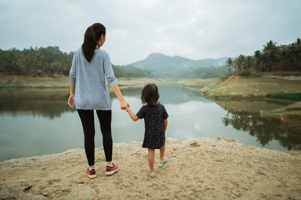A mother and his daughter on the edge of the lake — Stock Photo, Image