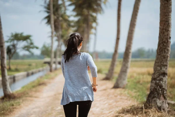 Una mujer corre en el arrozal —  Fotos de Stock