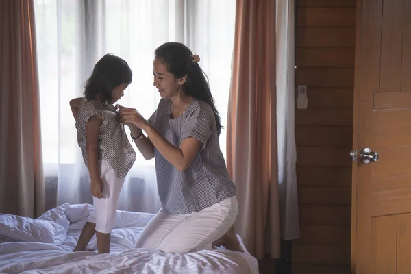 Stående mor bär kläder för dotter — Stockfoto