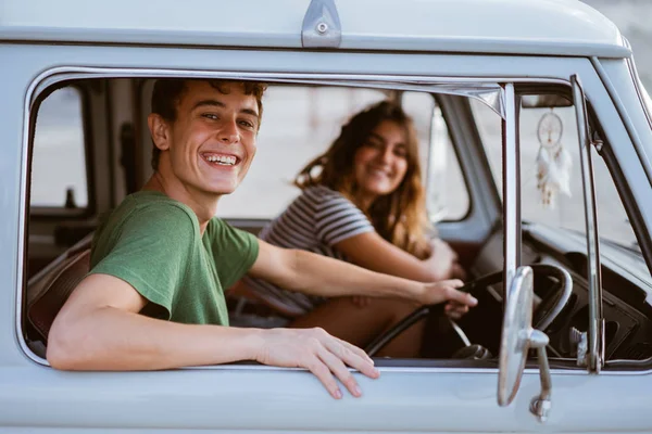 young people inside a car looking at camera