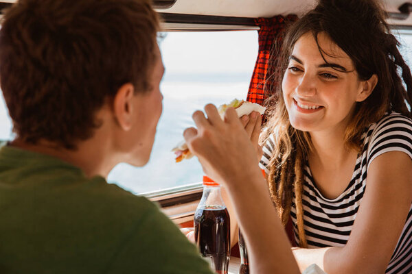 пара кавказских мужчин и женщин сидящих насладиться едой
