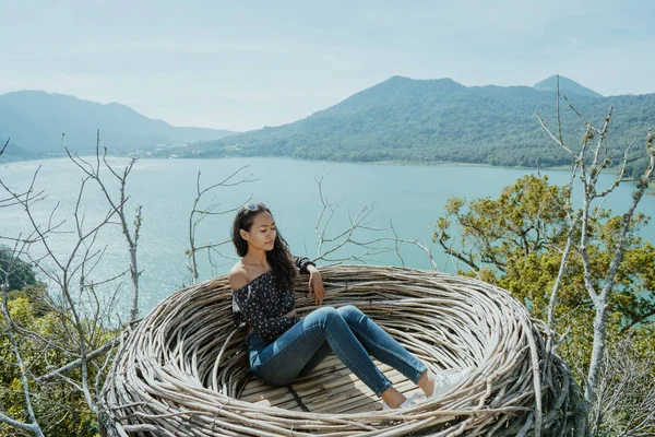 Asian woman sitting on a nest in nature — Stock Photo, Image