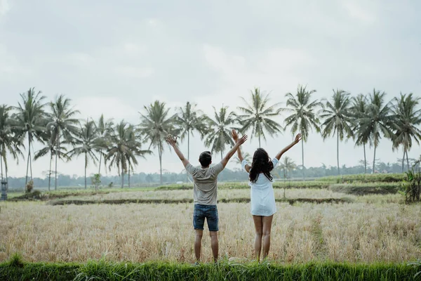 Wo couple angkat tangan sambil menikmati sawah — Stok Foto