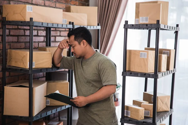 Jovem estressado verificando pacotes — Fotografia de Stock