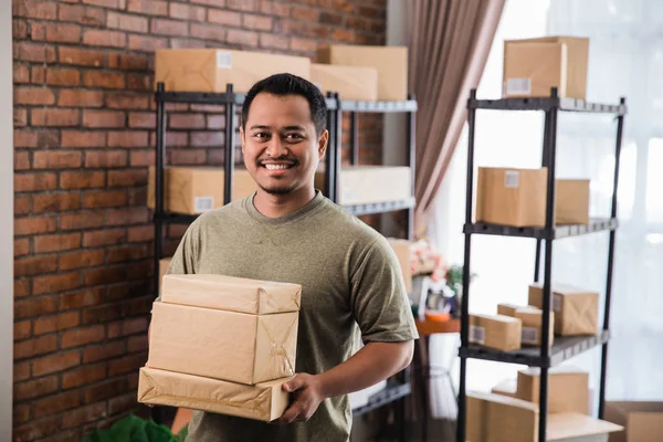 Mannen courier håller paketet arbete på paketet skeppshandel — Stockfoto