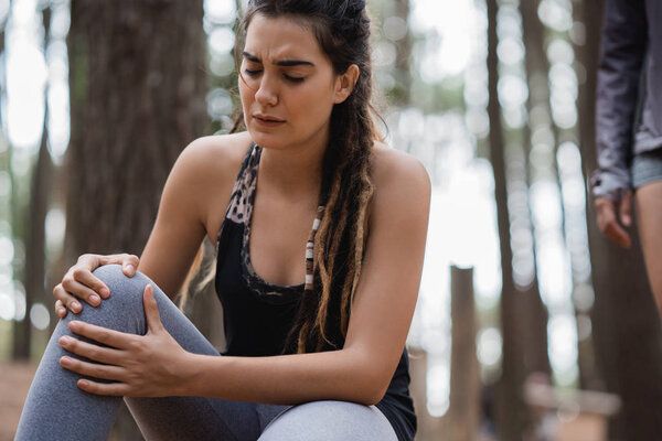 женщина чувствует боль в колене
