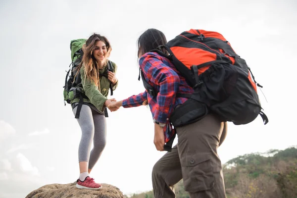 Kvinnliga vänner vandring hjälper varandra — Stockfoto
