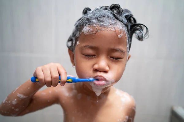 Малышка чистила зубы, принимая душ — стоковое фото