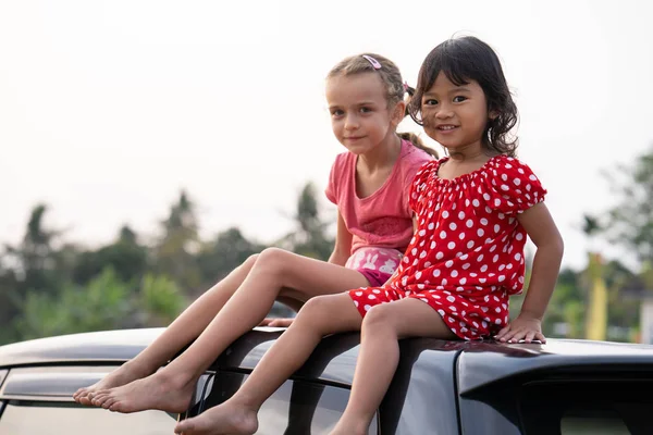Enfants profitant de leur temps assis sur le dessus de la voiture — Photo
