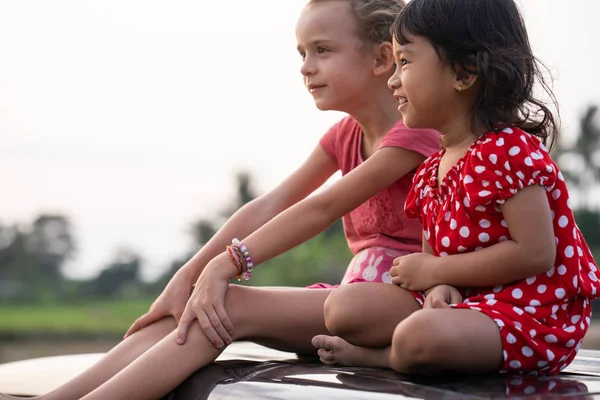 Niños disfrutando de su tiempo sentado en la parte superior del coche — Foto de Stock