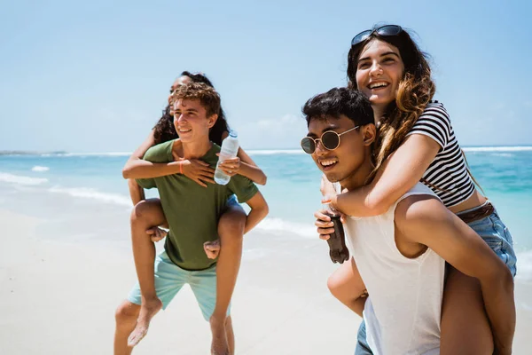 Jóvenes amigos alegres disfrutando del verano en la playa —  Fotos de Stock