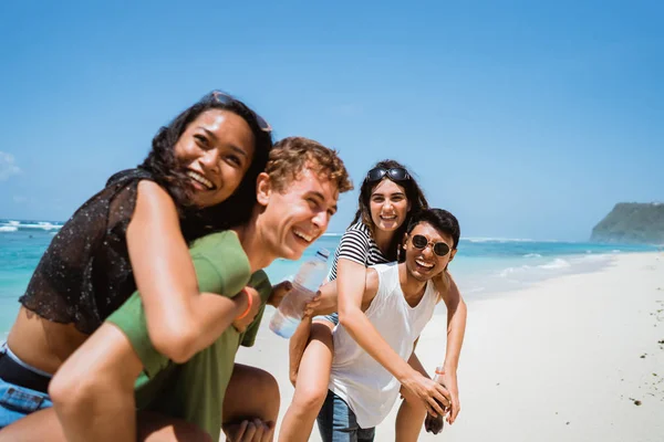Веселые юные друзья, наслаждающиеся летом на пляже — стоковое фото
