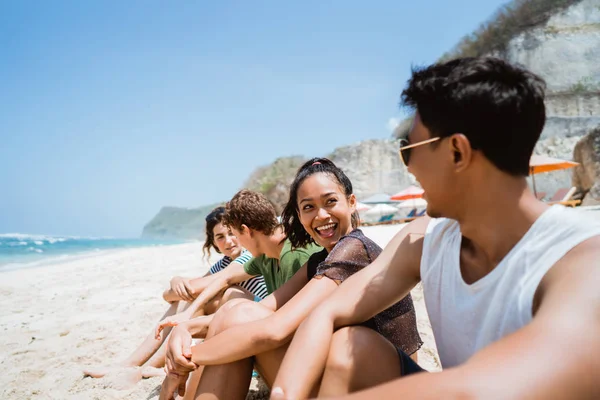 Desfrutar da praia com amigos sentados na areia — Fotografia de Stock