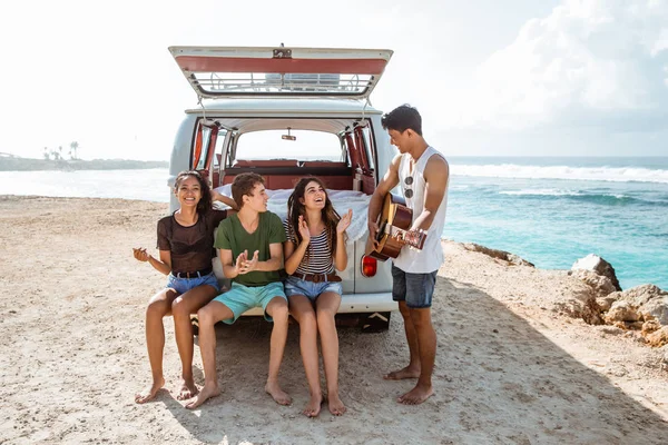 Hipster tocando guitarra para seus amigos — Fotografia de Stock