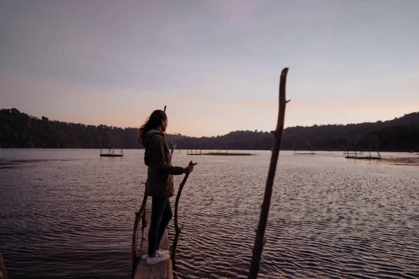 Asian woman enjoying sunrise near lake — Stock Photo, Image