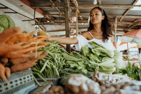 亚洲妇女摆姿势在热带市场销售蔬菜和水果 — 图库照片