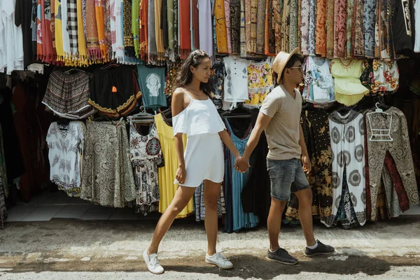 お土産市場店で休暇を一緒にしながら歩くアジア カップル観光客 — ストック写真
