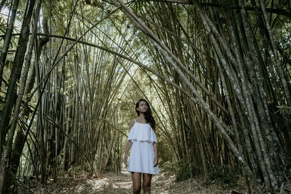 Woman in white dress enjoying nature in bamboo forest — Stock Photo, Image
