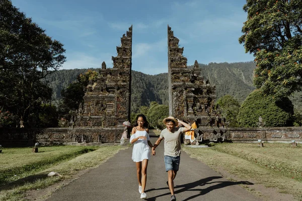 Feliz Casal Correndo Juntos Através Bali Portão Tradicional Bedugul — Fotografia de Stock