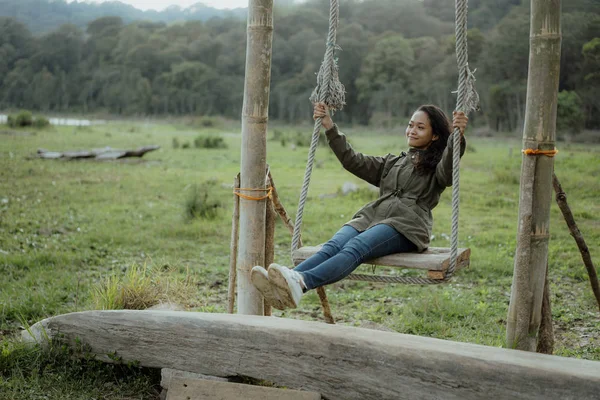 asian woman swing her self in a countryside