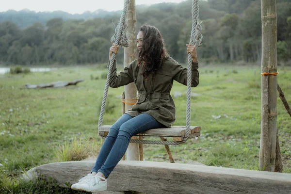 Asian woman swinging in nature — Stock Photo, Image