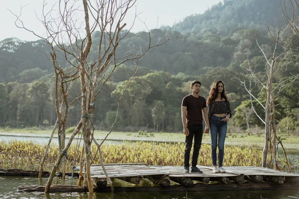 Paar sitzt auf einem schwimmenden Holzbrett auf einem See — Stockfoto
