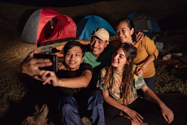 grup arkadaşıyla kamp, kamp ateşi etrafında selfie kadar kapatın