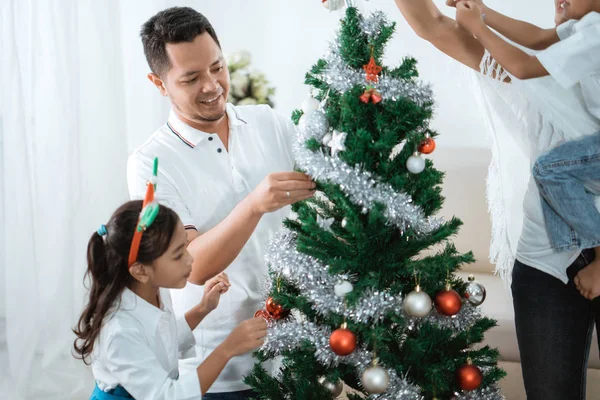 happy family decorating christmas tree