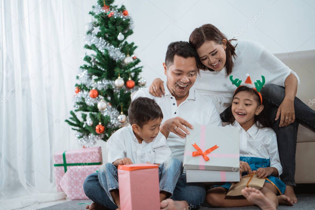 excited family open the gift box together