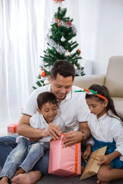 Keluarga mencoba untuk membuka hadiah Natal mereka bersama-sama — Stok Foto