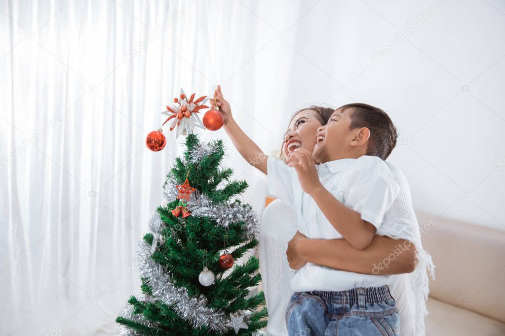 mother and son decorating christmas tree